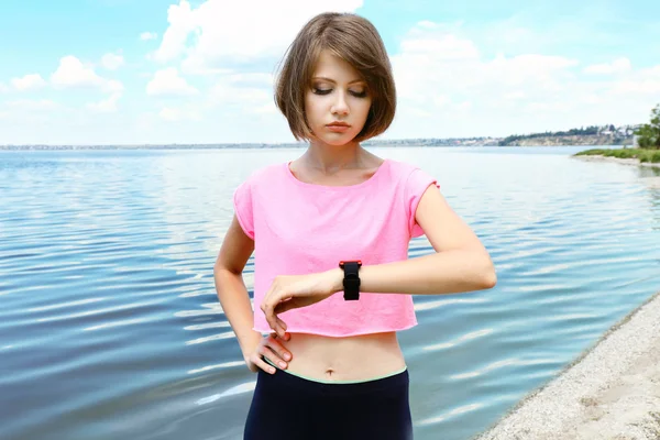 Runner kijken naar sport smart watch buitenshuis — Stockfoto