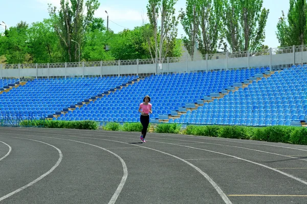 Młoda kobieta jogging na stadion — Zdjęcie stockowe