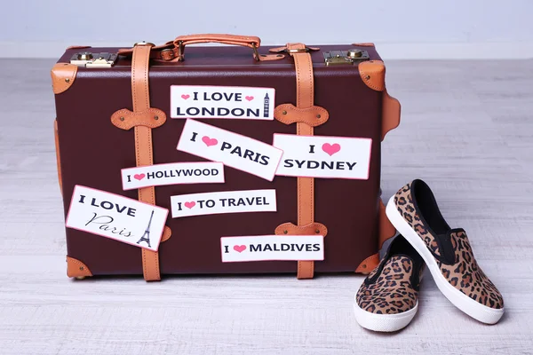 Suitcase with stickers on floor — Stock Photo, Image