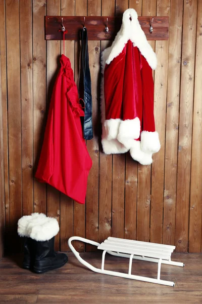 Kostium Santa wiszące na tle ściany drewniane — Zdjęcie stockowe