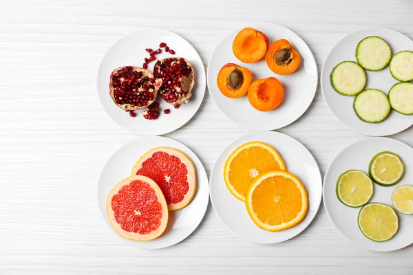 Verschiedene Produkte auf Untertassen auf Holztisch, Draufsicht — Stockfoto