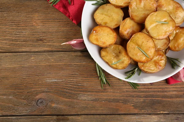 Lahodné pečené brambory s rozmarýnem v misce na stole zblízka — Stock fotografie