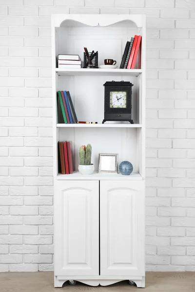 Boeken en decor op planken in kast — Stockfoto