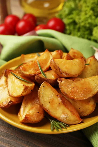 Baked potato wedges on wooden table, closeup — Stock Photo, Image