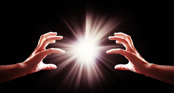 Menschenhände mit Licht auf schwarzem Hintergrund — Stockfoto