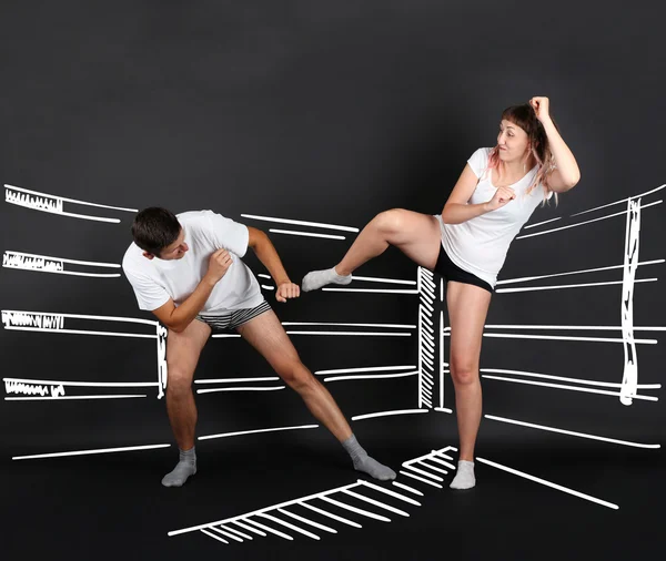 Young couple fighting at the boxing ring, on black background — Stock Image Young couple fighting at the boxing ring, on black background Royalty Free Stock Photos