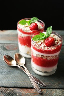 tatlı taze çilek, krem ve granola, koyu arka plan üzerinde ahşap tablo