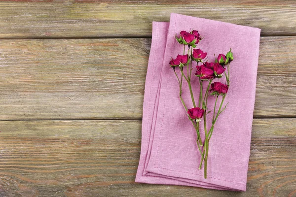 Mooie droge bloemen op servet op houten achtergrond — Stockfoto