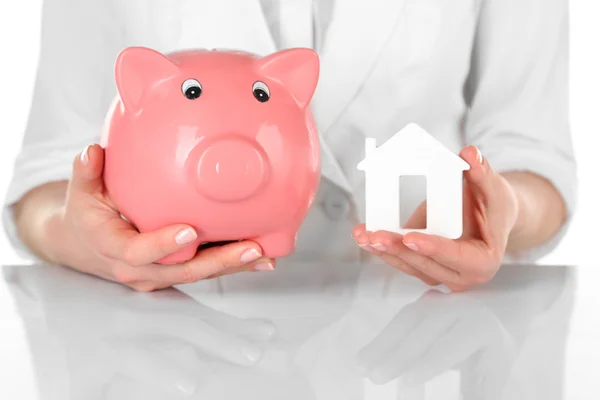 Woman holding model of house and piggy bank close up — Stock Photo, Image