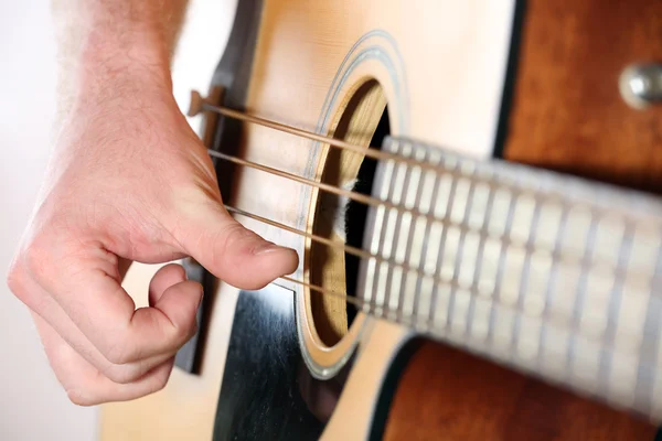 Young man playing on acoustic guitar close up — Stock Photo, Image