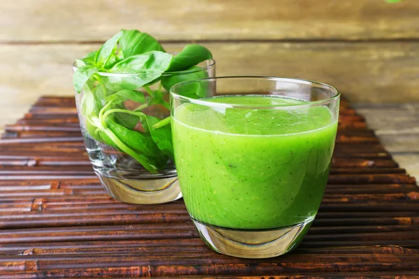 Verre de jus vert sain avec des épinards et du basilic sur la table gros plan — Photo