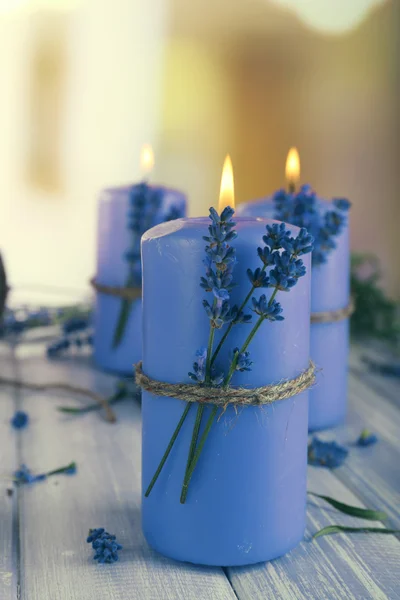 Свечи с лавандовыми цветами на ярком фоне — стоковое фото