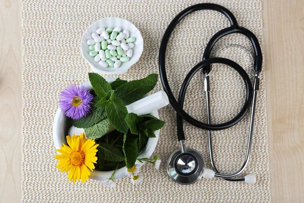 Alternative medicine herbs and stethoscope on wooden table background — Stock Photo, Image
