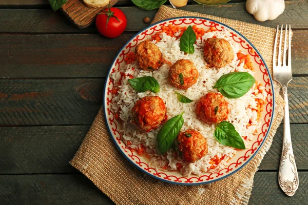 Bolas de carne en salsa de tomate con arroz hervido y lentejas, cuchara de madera sobre fondo de madera —  Fotos de Stock