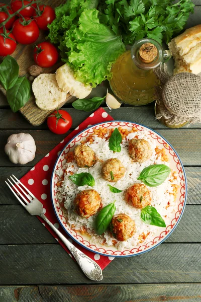 Fleischbällchen in Tomatensauce mit gekochtem Reis und Linsen, Holzlöffel auf hölzernem Hintergrund — Stockfoto