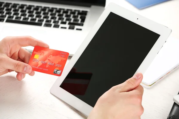Uomo in possesso di carta di credito e tablet su sfondo di lavoro — Foto Stock