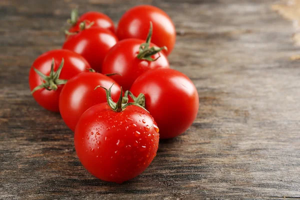 Pilha de tomate cereja no fundo de madeira — Fotografia de Stock