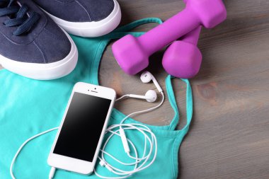Hareket eden telefon ve kulaklık ile spor için ahşap masa, closeup ayarla