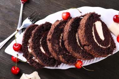 Lezzetli çikolata rulo beyaz tabak içinde ahşap masa, portre