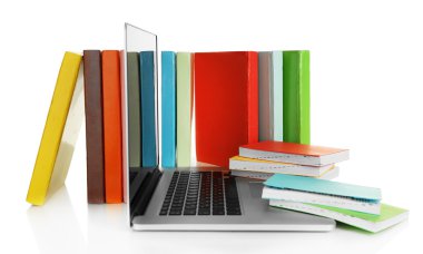 Kitap üzerinde beyaz izole dizüstü bilgisayar ile yığını