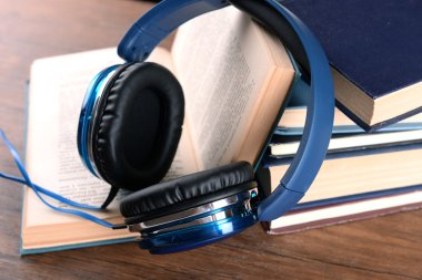 Kitap ve sesli kitaplar kavram üzerinde ahşap masa, tatlı olarak kulaklık