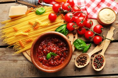 Makarna spagetti domates, sos bolognese, peynir ve fesleğen rustik ahşap zemin üzerine