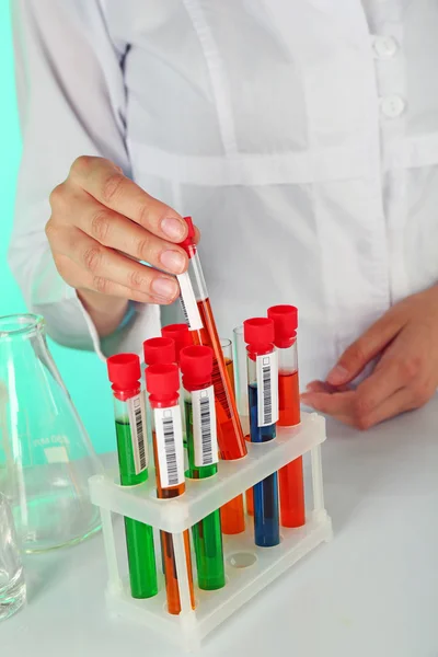 Test tubes with colorful liquid in scientist hand, closeup — Stock Photo, Image