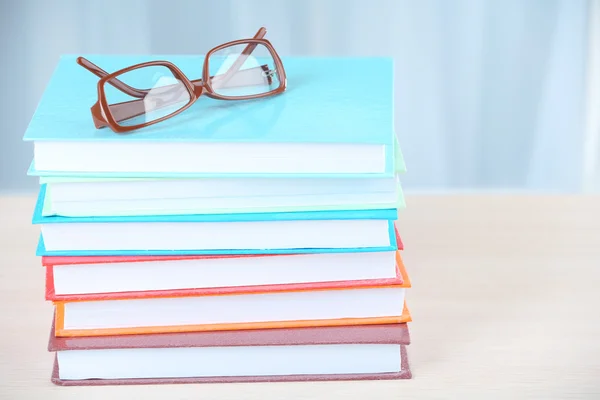 Stapel boeken met een bril op houten tafel op kamer — Stockfoto