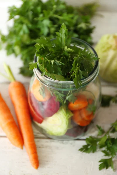 新鲜蔬菜在玻璃瓶上木桌前，特写 — 图库照片
