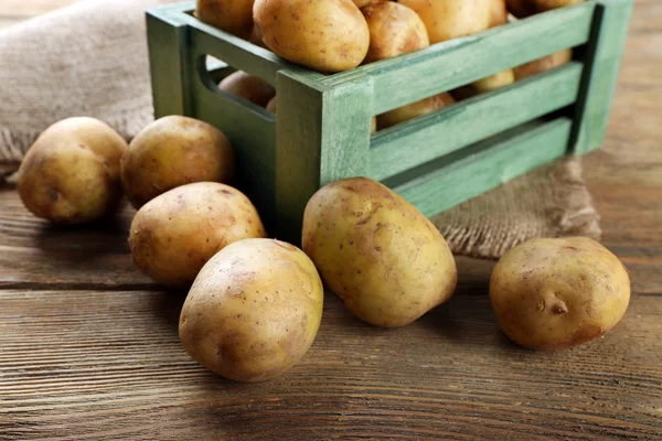 Batatas jovens em caixa na mesa de perto — Fotografia de Stock