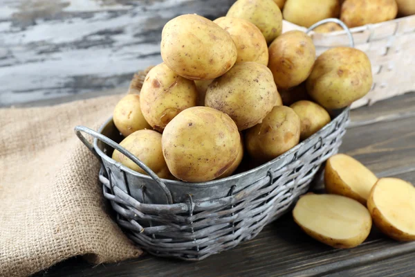 Batatas jovens em cestas de vime em mesa de madeira close-up — Fotografia de Stock