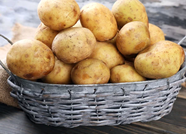 Nové brambory v proutěných koších na dřevěný stůl zblízka — Stock fotografie