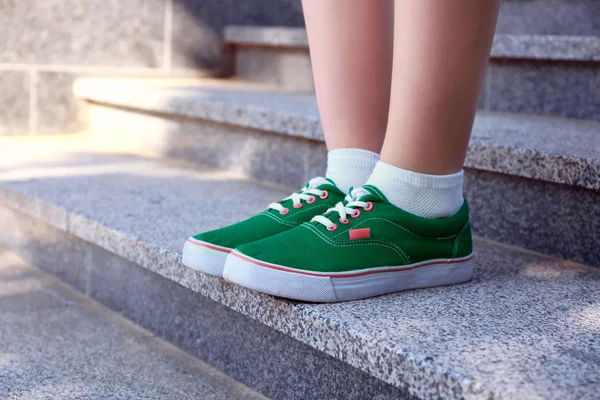 Female feet in green gumshoes on stone stairs — Stock Photo, Image