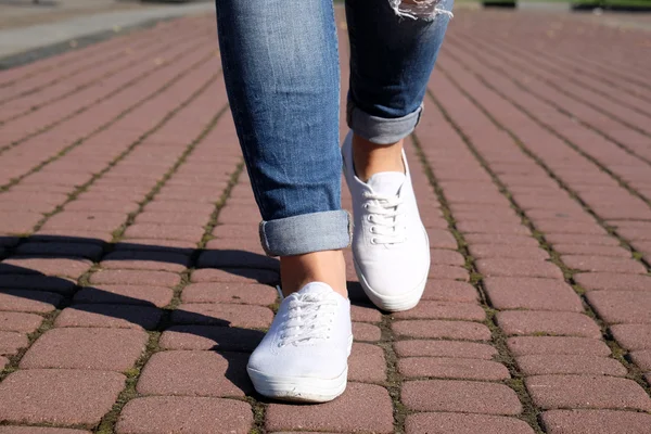 Female feet on paving stone background — Stock Photo, Image