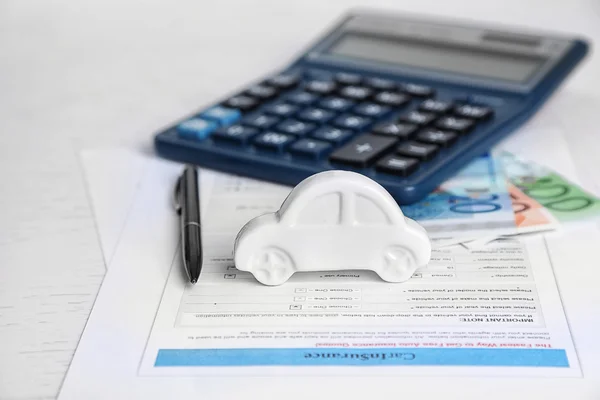 Coche de juguete, dinero, documentos y calculadora en la mesa. Concepto de seguro de coche —  Fotos de Stock