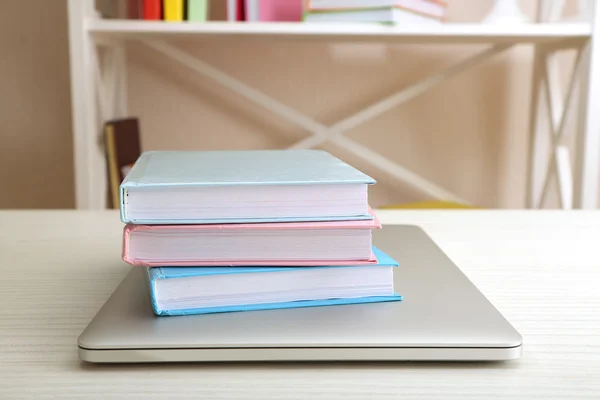 Stack of books with laptop on table close up — Stock Photo, Image