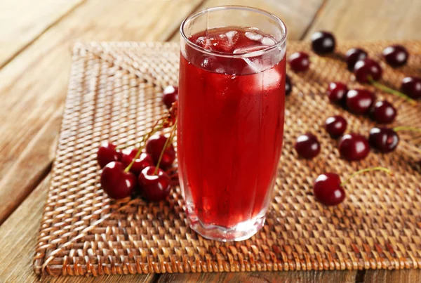 Glass of cherry juice on wooden table, closeup — Stock Photo, Image