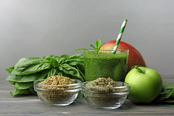 Succo sano verde con frutta ed erbe su sfondo grigio — Foto Stock