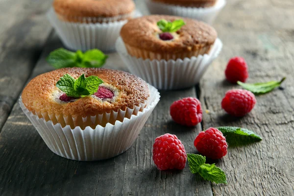 Delicious cupcakes with berries and fresh mint on wooden table close up — Stock Photo, Image