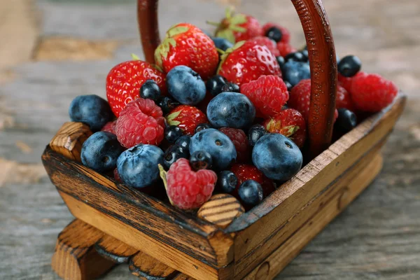 Zoete smakelijke bessen in mand op houten tafel close-up — Stockfoto