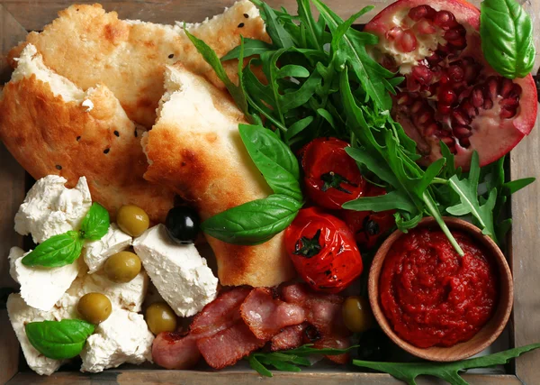 Ingrediënten van mediterrane gerechten, op houten dienblad, op houten achtergrond — Stockfoto