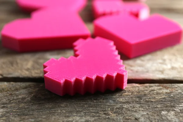 Plastic hearts on wooden table, closeup — Stock Photo, Image