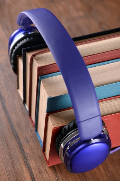 Livros e fones de ouvido como conceito de livros de áudio em mesa de madeira, close-up — Fotografia de Stock