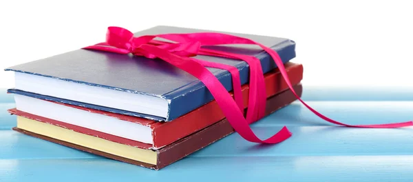 Montón de libros con cinta sobre mesa aislada sobre blanco —  Fotos de Stock