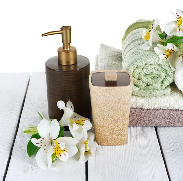 Zachte handdoeken met dispenser en bloemen geïsoleerd op wit — Stockfoto