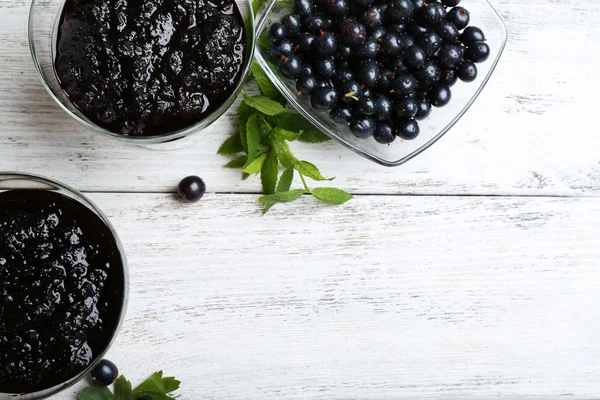 Tasty currant jam with berries on table close up — Stock Photo, Image