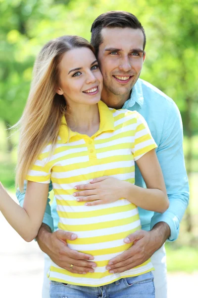 Young pregnant woman with husband in park — Stock Photo, Image