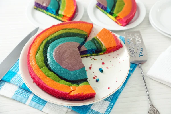 Delicioso pastel de arco iris en plato, sobre fondo claro — Foto de Stock