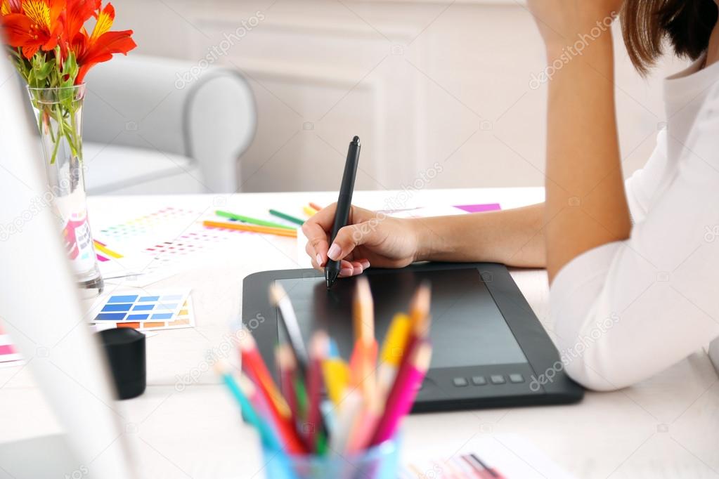 Artist drawing on graphic tablet in office