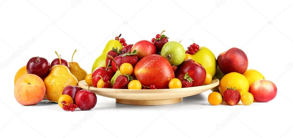 Heap of fresh fruits and berries on plate isolated on white
